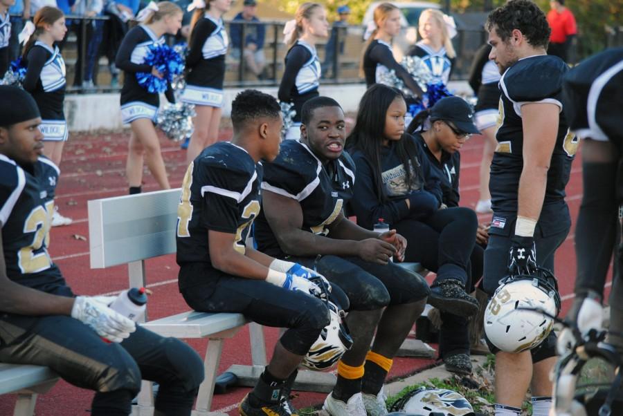 Seniors Jabriee Mason, Dallas Yates and G’Lina Matthews on the bench at the home quarter-final game. While the players are on the field, Yates makes sure they stay hydrated by refilling their water bottles. “My favorite part of being the manager is standing on the sidelines watching the games,” said Yates. PHOTO BY CHRISTINE POLITTE