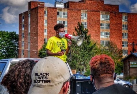 Megaphone in hand, Michael Simmons, sophomore, delivers a speech to protesters before setting off to march through U. City. “It was very important to me that I made sure my voice was heard,” Simmons said. Simmons was one of the main leaders who helped to organize the protest.