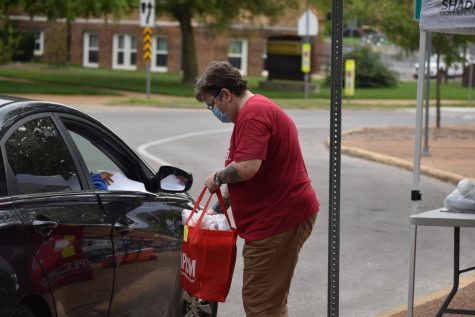 Peggy Halter, English teacher, hands out books  to students in her literature classes during a drive-through school supply pickup in September.