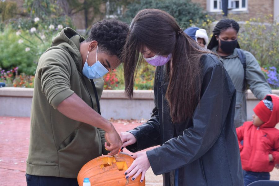 During the afternoon carving session, Cameron Martin (left) and Maxine Adams (right), juniors, work together to carve a pumpkin for the evening's events.