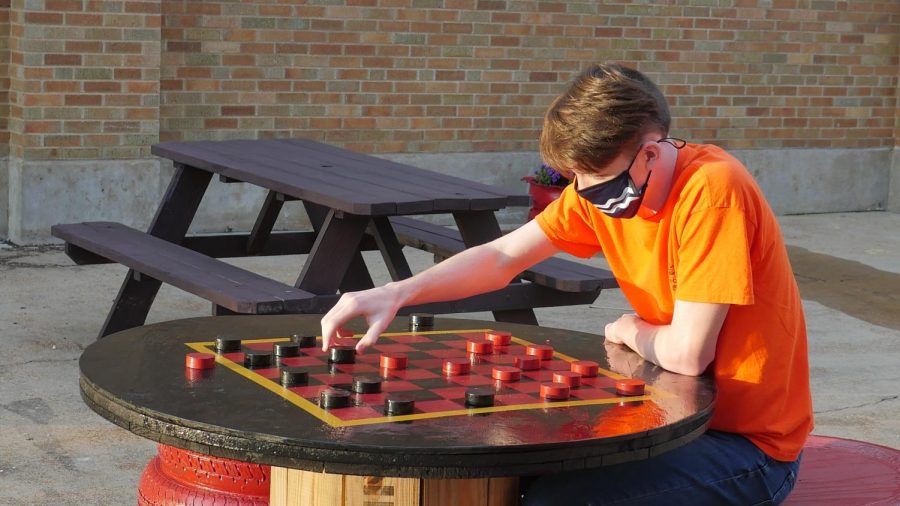 Adam Holahan, senior, sets up a checkers board.