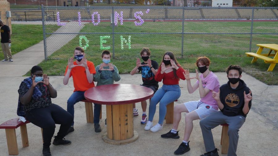 A group of Black Academy students sit in the new school courtyard after its unveiling.