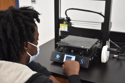 Coleman works with the 3D printer in the makerspace