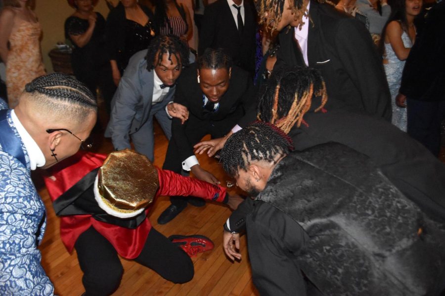 Mekhai Gover, senior and Prom King, dances while his friends cheer him on. Kehari Evans, senior, was one of those friends. My favorite part about promwas the long dresses, because it had me play twister, Evans said. My other favorite part of prom was watching my best friend win Prom King.