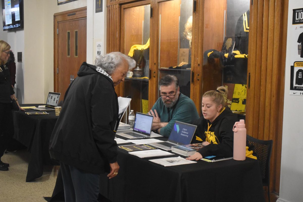 Benjamin Williams and Reese Sherman, social studies teachers, explain department information a guest. This [open house] was, for me, a great opportunity to meet family in the district that will soon be attending the high school, Williams said.